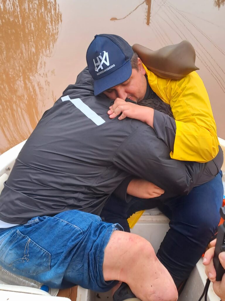 Garcia da Hadassa abraça morador em barco de buscas - Colab./Ass. de Imprensa