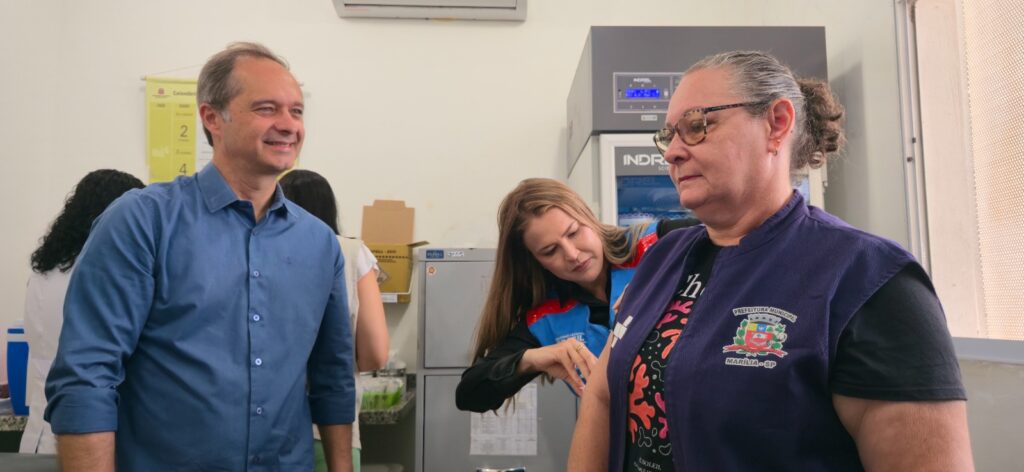 Vereador Danilo Bigeschi observa servidora tomar vacina - Colab./Ass. de Imprensa