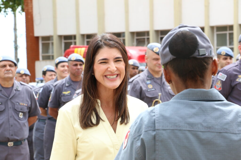 Márcia Mesquita Serva Reis conversa com policial - Colab./Ass. de Imprensa